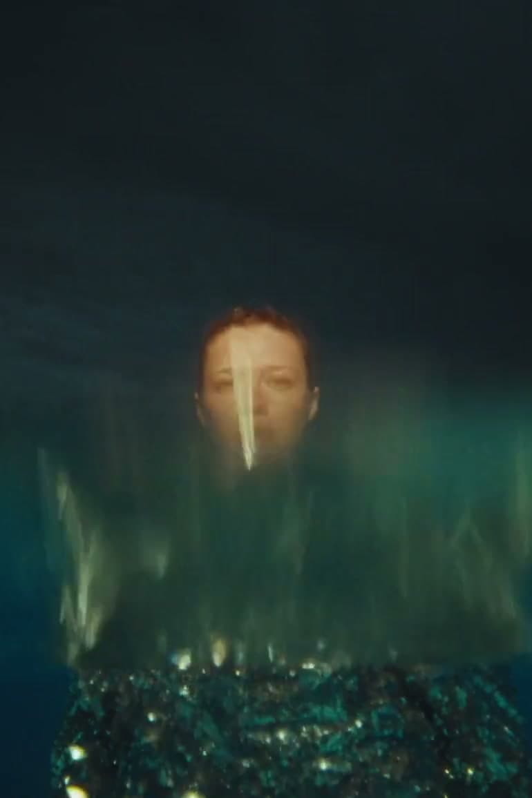 Woman's face surfacing through dark water